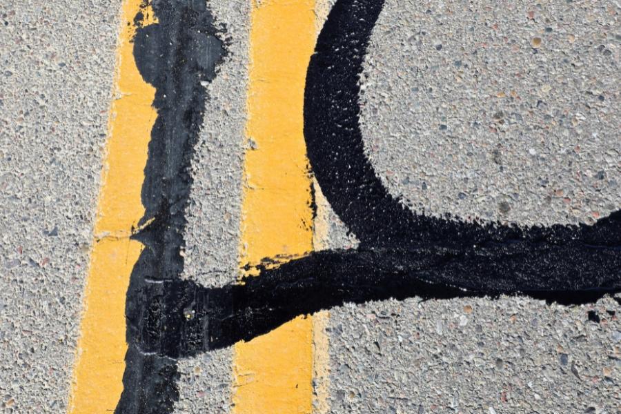 A road with fresh asphalt repair lines. 