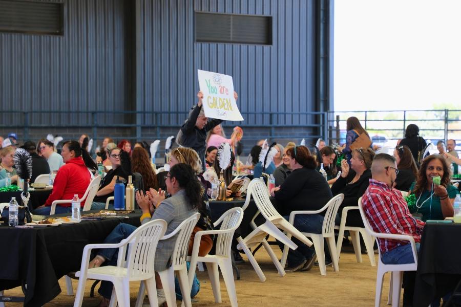 A woman holding a sign in a crowd. 